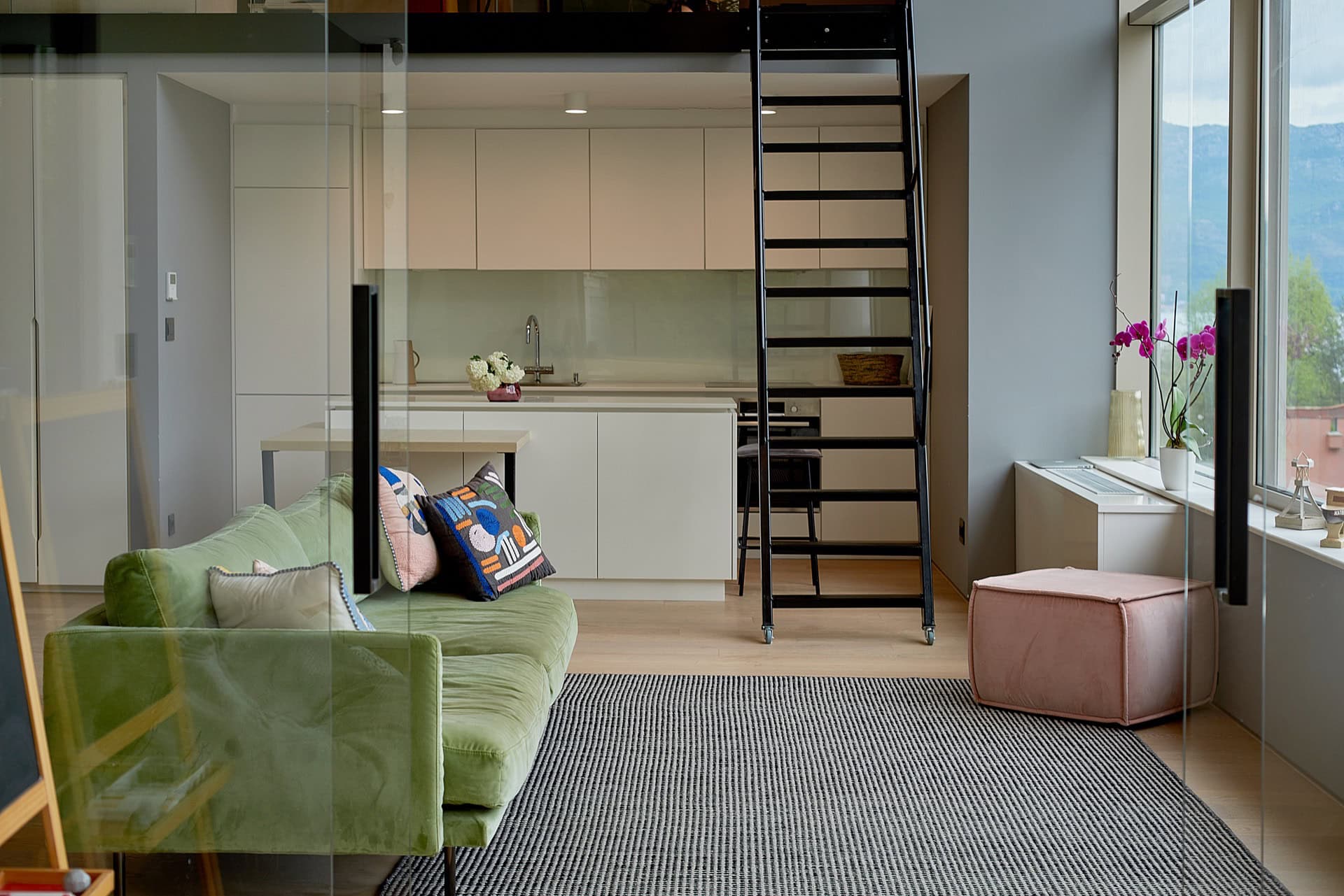 Modernes Wohnzimmer mit Küche und Treppe zur zweiten Ebene in einer Wohnung im Zentrum von Budva, Montenegro.