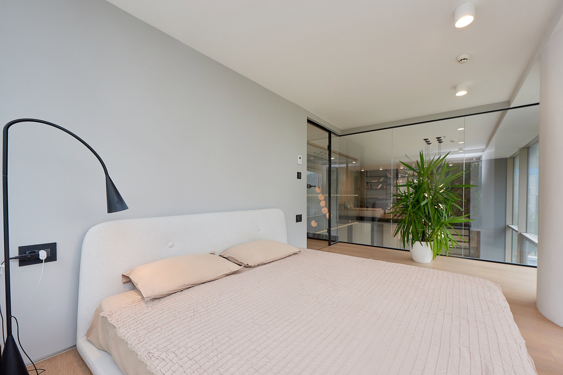 Modernes Schlafzimmer mit Doppelbett und Glastrennwand in einer Wohnung im Zentrum von Budva, Montenegro.