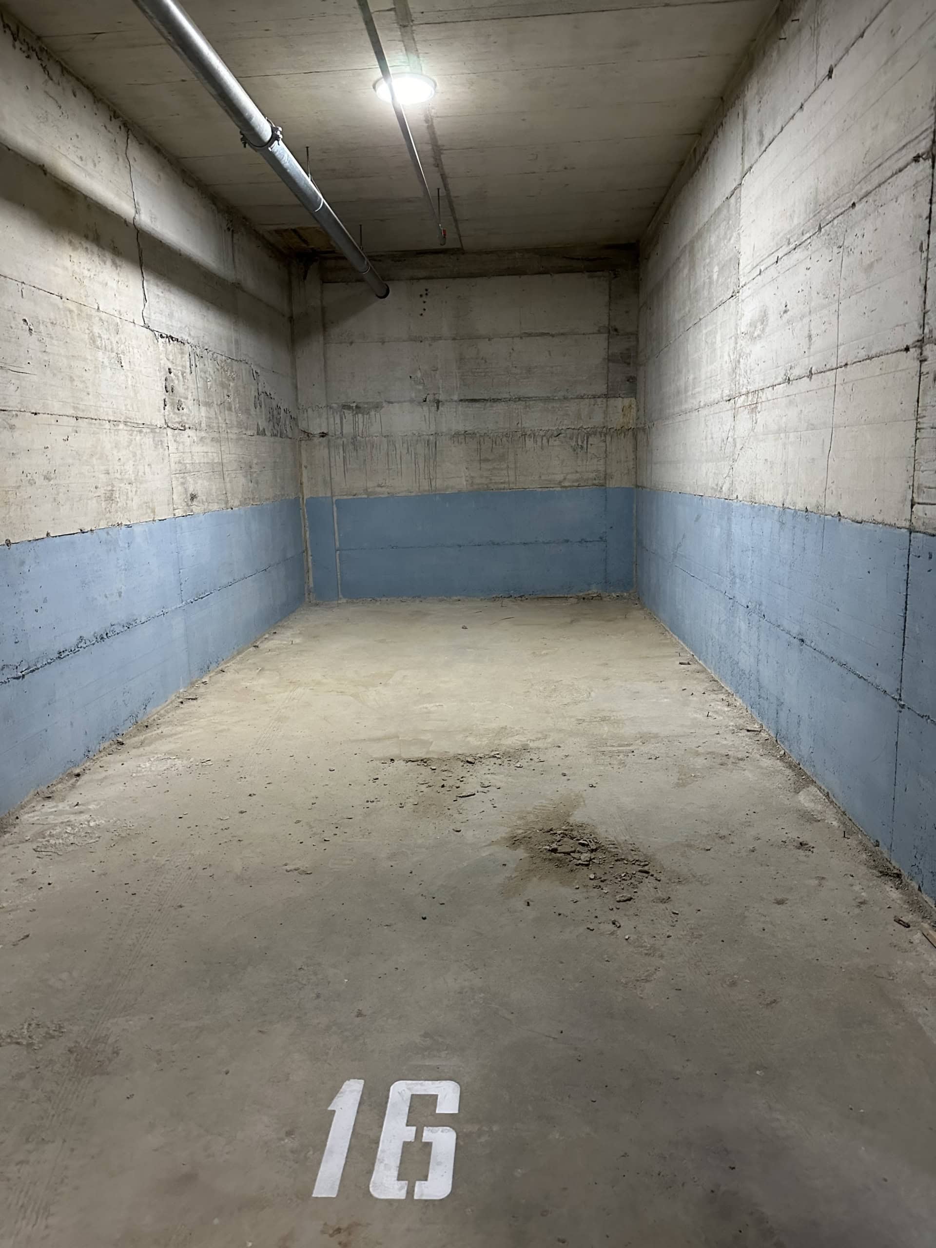 Parkplatz Nr. 16 in der Tiefgarage der Wohnanlage in Bečići, Montenegro: Betonwände und ebener Boden.