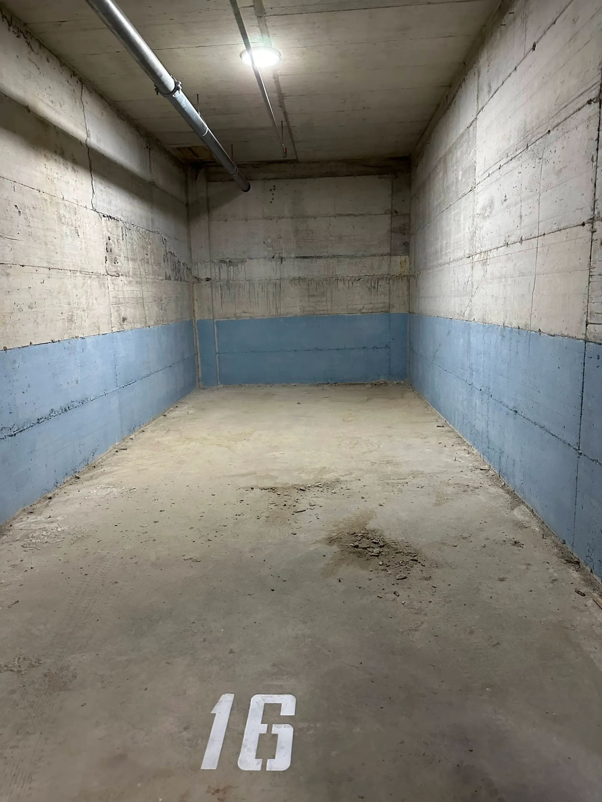 Parkplatz Nr. 16 in der Tiefgarage der Wohnanlage in Bečići, Montenegro: Betonwände und ebener Boden.
