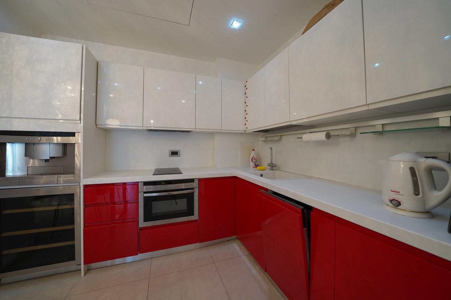 Moderne Küche mit roten und weißen Fronten in einer Wohnung, Budva, Montenegro: Einbaugeräte und helles Interieur.
