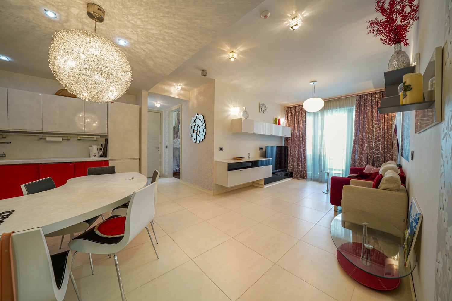 Modernes Wohnzimmer mit Küche in einer Wohnung in Budva, Montenegro: helles Interieur, Essbereich und Polstermöbel.