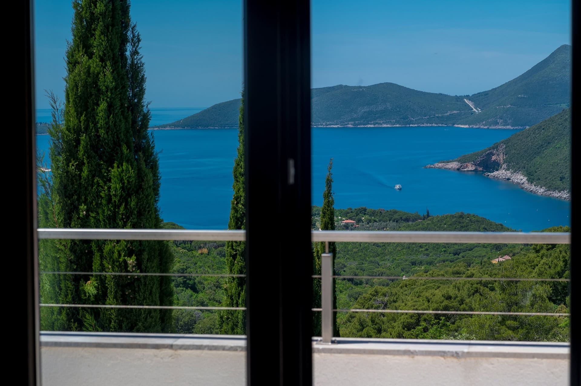 Widok z balkonu willi w Žanjicach, Czarnogóra: panorama Morza Adriatyckiego, gór i cyprysów na wybrzeżu Herceg Novi.