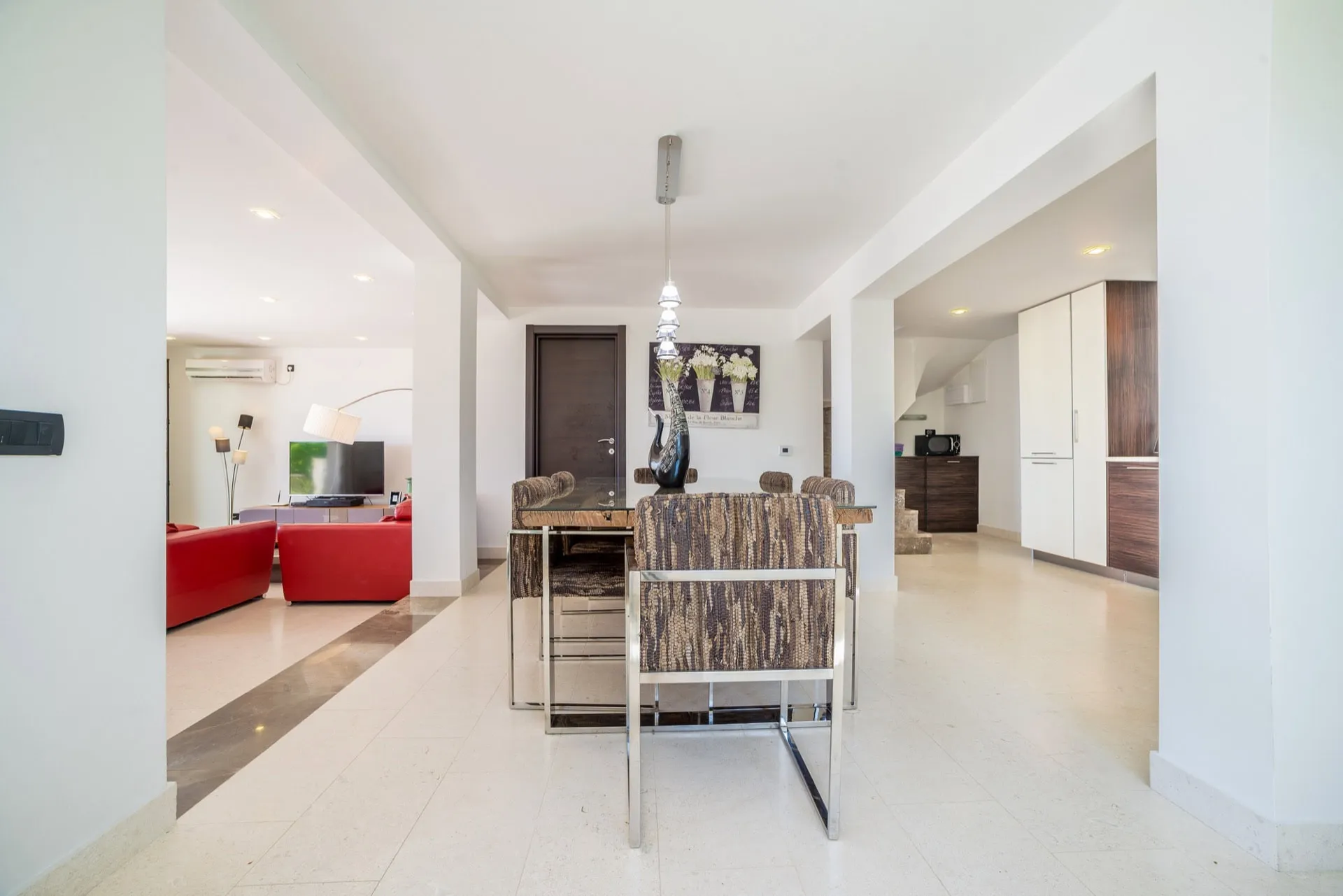 Bright living room with dining area in a villa in Zanjice, Montenegro: modern furniture, marble floor, and stylish decor.