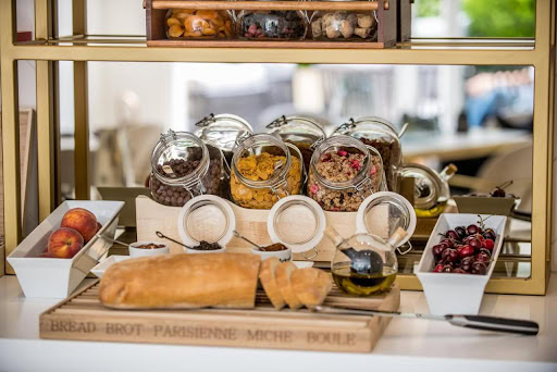 Frühstück im Hotel Budva, Montenegro: frisches Brot, Obst und Müsli auf einer stilvollen Servierstation im Küchenbereich.