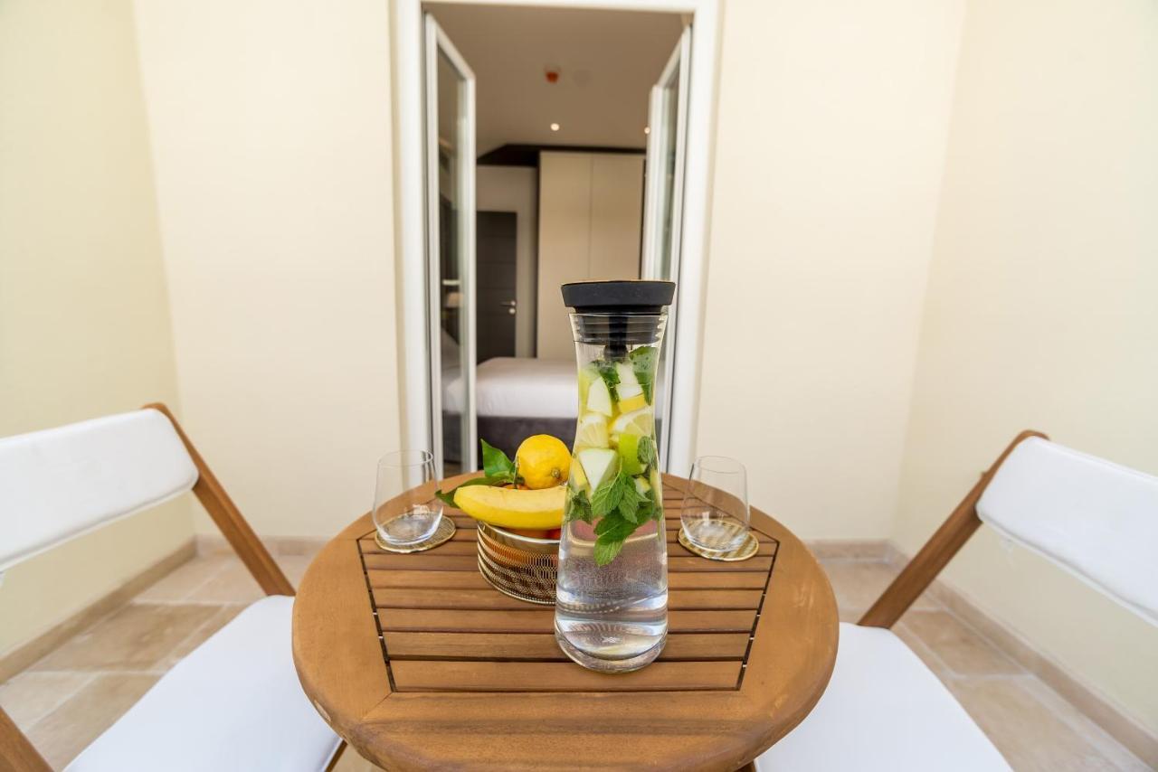 Gemütlicher Balkon mit Holztisch und Früchten im Hotel in Budva, Montenegro, Blick auf das moderne Zimmerinterieur.
