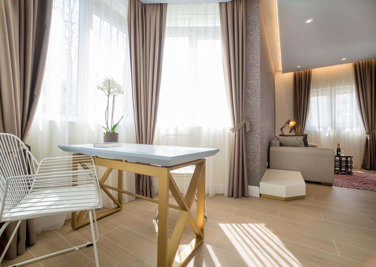 Modernes Wohnzimmer in einem Hotel in Budva, Montenegro: Designertisch mit goldenen Beinen, weiches Sofa und Panoramafenster.