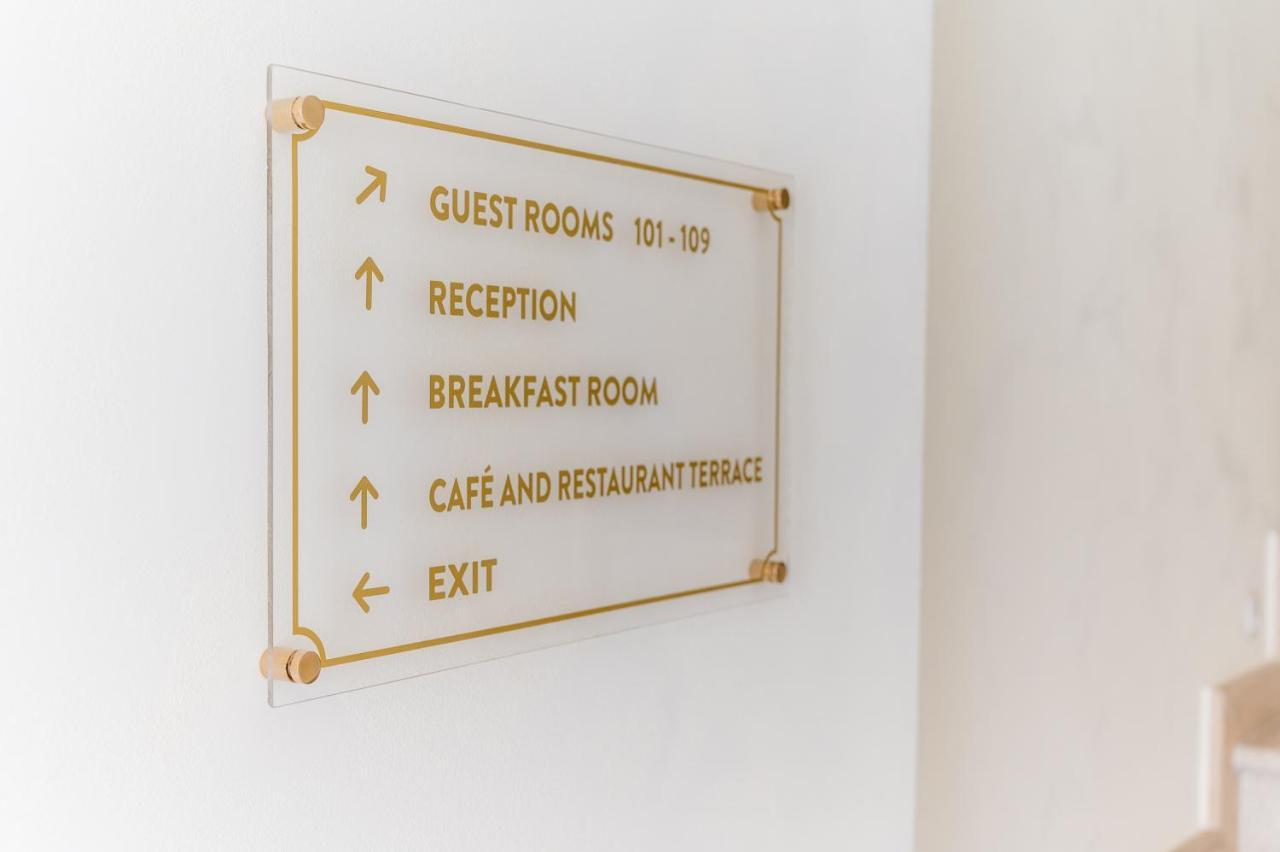 Navigationsschild im Hotel in Budva, Montenegro: Wegweiser zur Rezeption, zu den Zimmern, zum Restaurant und zum Ausgang im Hotelinterieur.