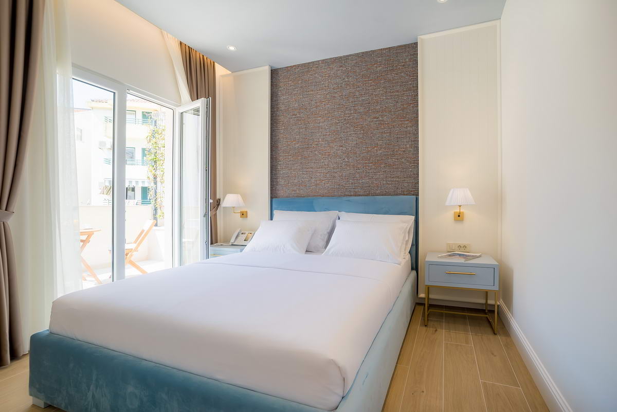 Modernes Schlafzimmer in einem Hotel in Budva, Montenegro: Doppelbett, Akzentwand und Zugang zum Balkon.