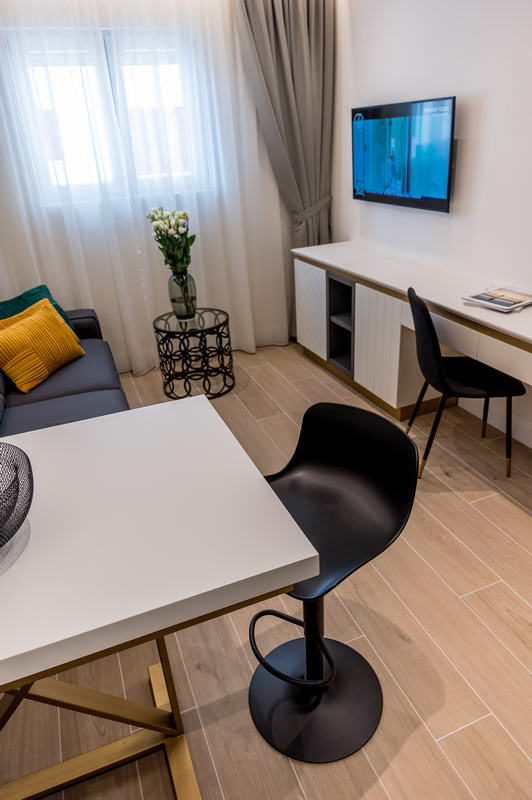 Modernes Wohnzimmer in einem Hotel in Budva, Montenegro: stilvolle Möbel, Essbereich, TV und helles Interieur.