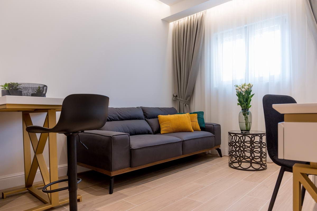 Modernes Wohnzimmer in einem Hotel in Budva, Montenegro: graues Sofa, stilvoller Tisch und Designermöbel im Interieur.