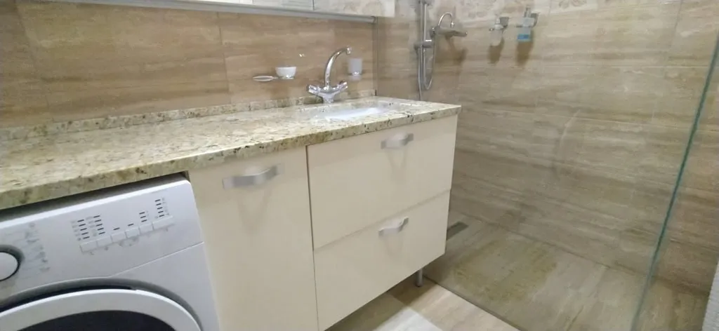 Modernes Badezimmer mit Dusche und Waschmaschine in einer Wohnung, Bečići, Montenegro.