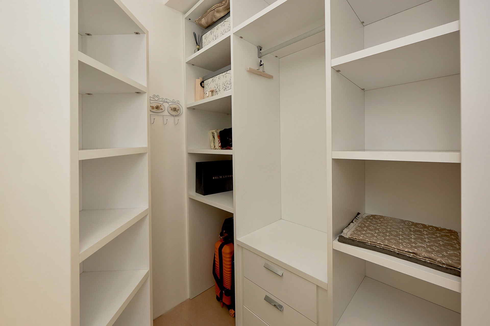 Weiße Ankleidekammer mit Regalen und Schubladen im Penthouse in Bečići, Montenegro