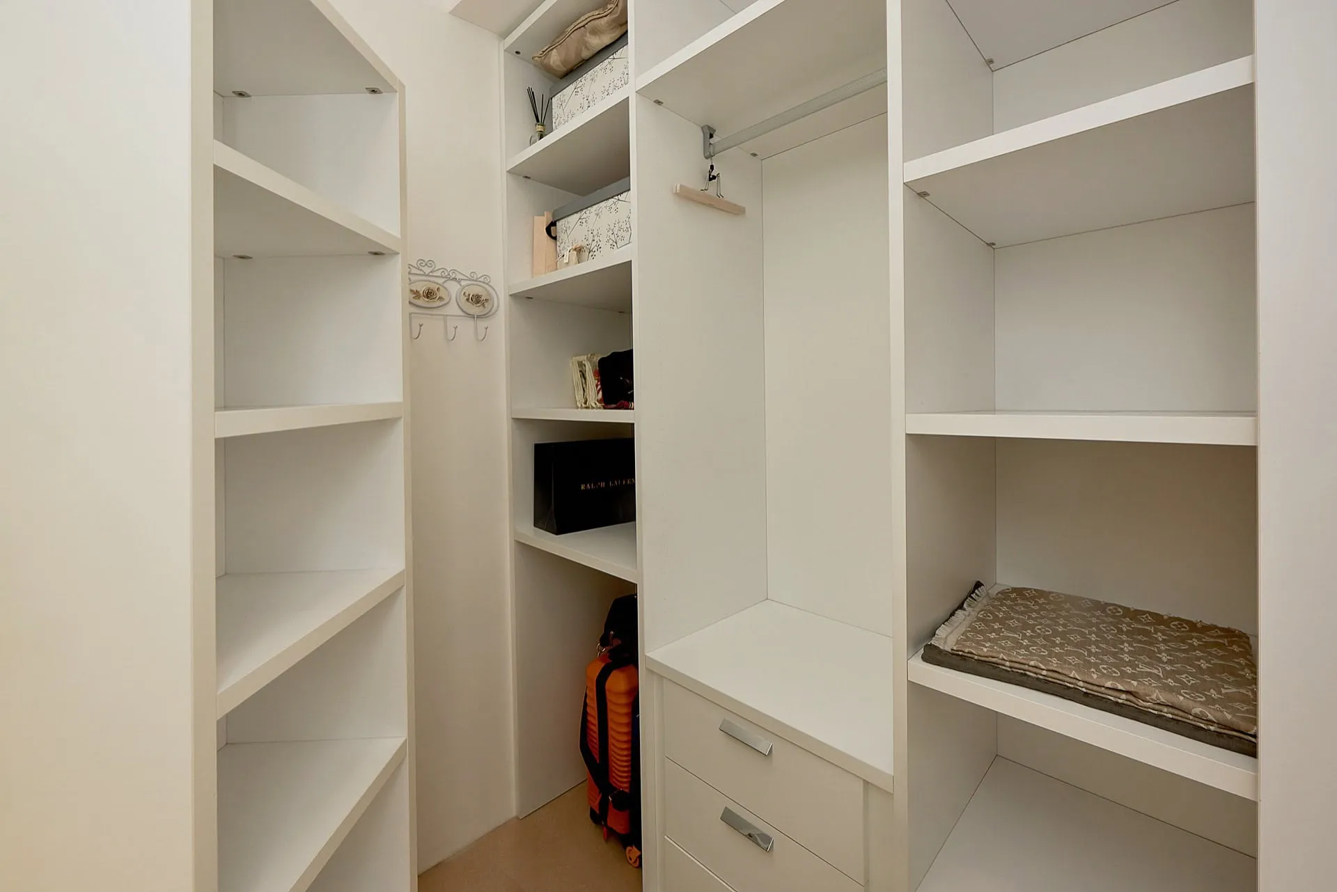 Weiße Einbaukleiderschränke mit Regalen, Kleiderstange und Schubladen im Penthouse in Bečići, Montenegro