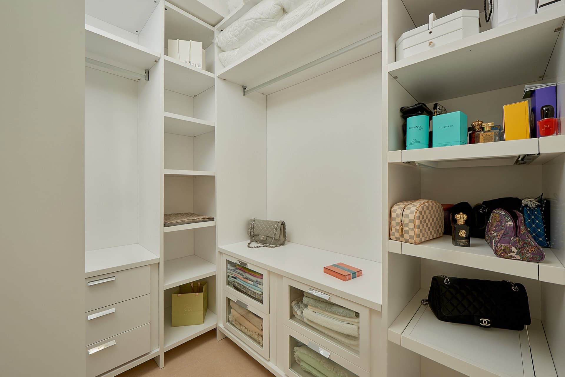 Weiße Einbauschrank-Garderobe mit Regalen und Schubladen im Penthouse in Bečići, Montenegro
