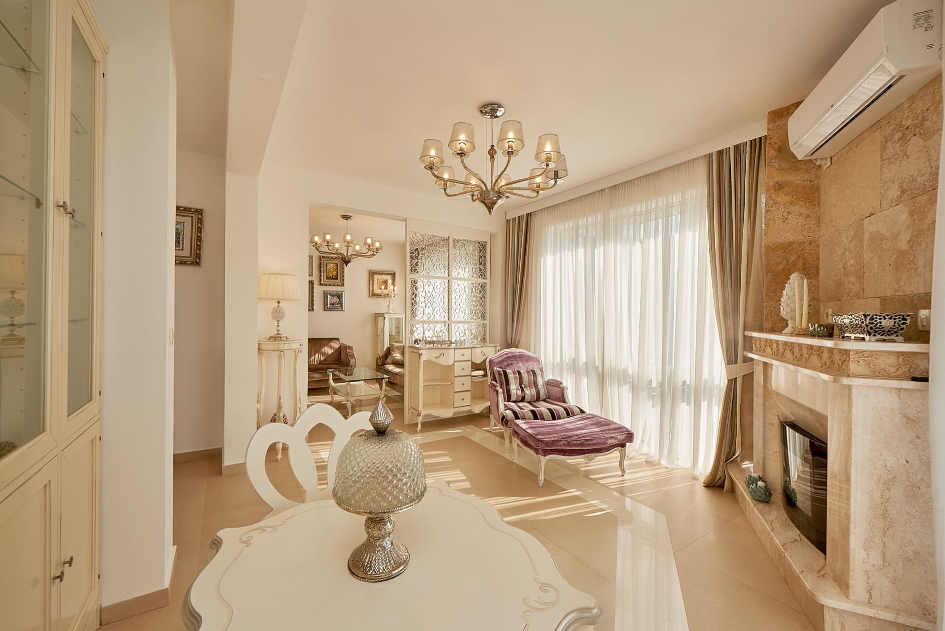 Geräumiges Wohnzimmer mit Kamin, klassischen Möbeln und Panoramafenster im Penthouse in Bečići, Montenegro