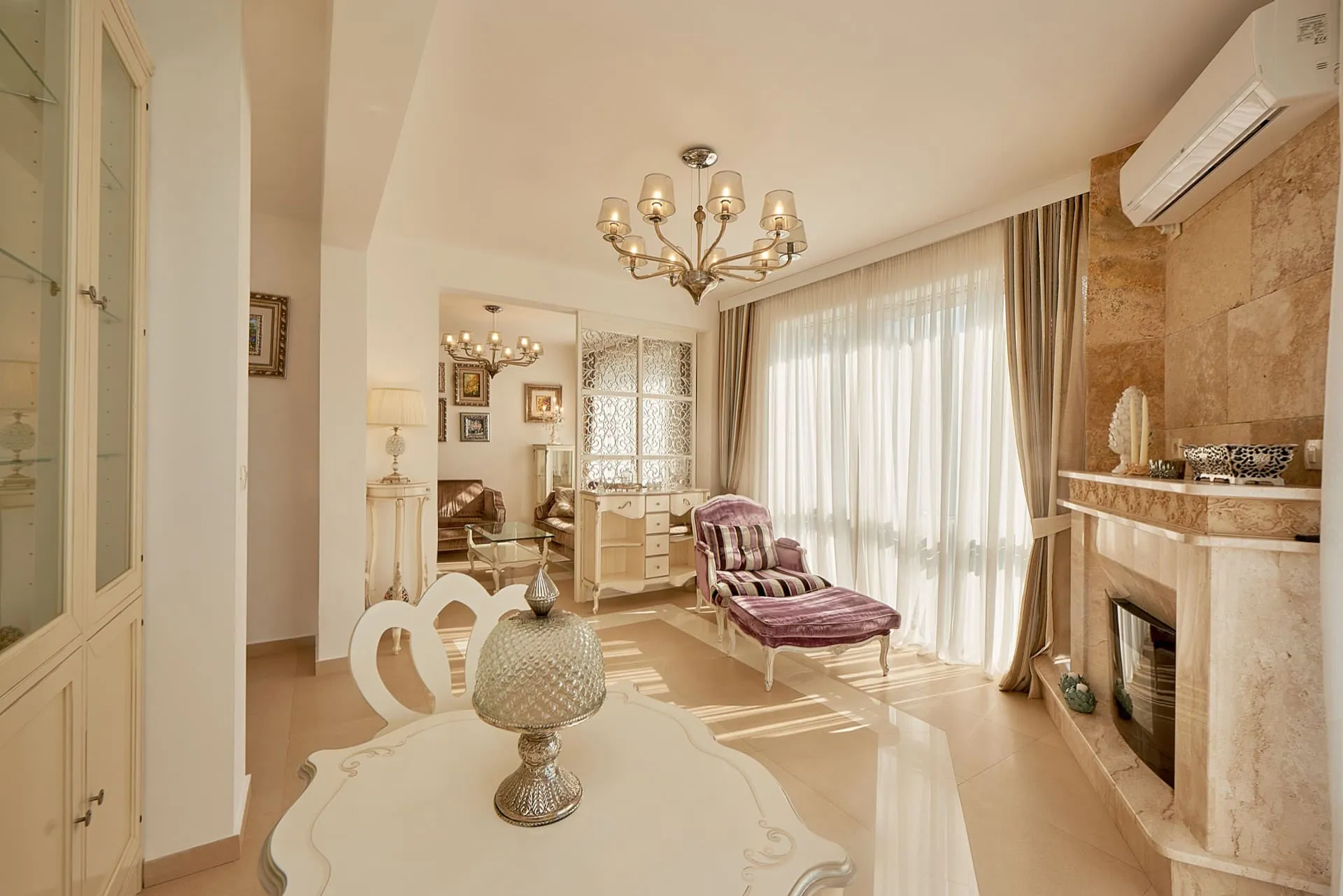 Geräumiges Wohnzimmer mit Kamin, klassischen Möbeln und Panoramafenster im Penthouse in Bečići, Montenegro