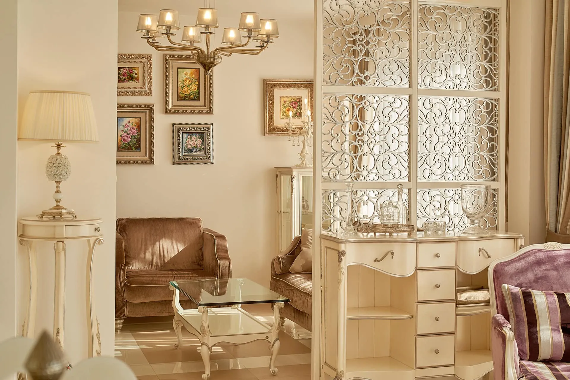 Wohnzimmer im klassischen Stil mit weißen Möbeln, geschnitzter Trennwand und Gemälden in einem exklusiven Penthouse in Bečići, Montenegro
