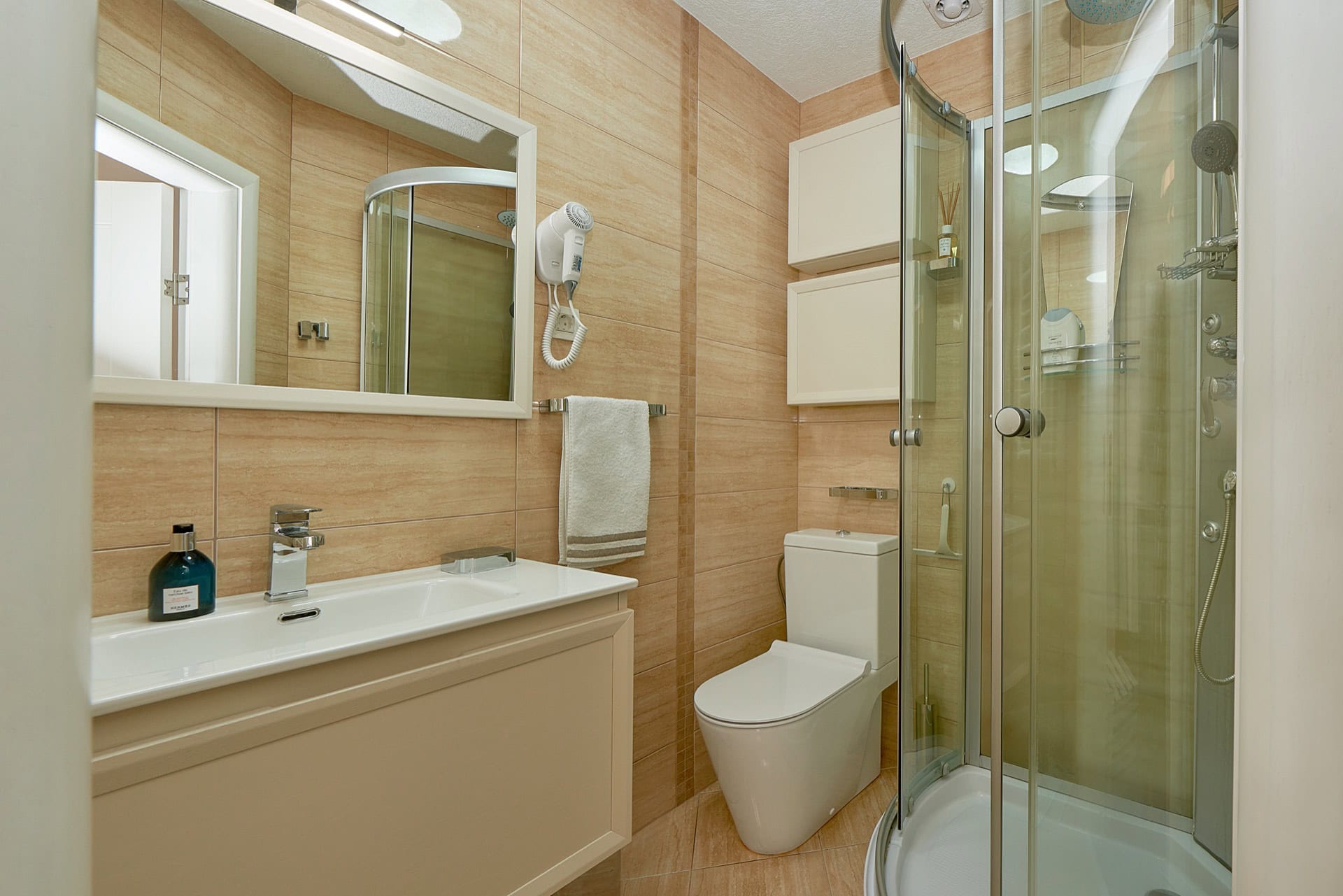 Modernes Badezimmer mit Dusche und weißer Sanitärkeramik in einer Wohnung in Bečići, Montenegro