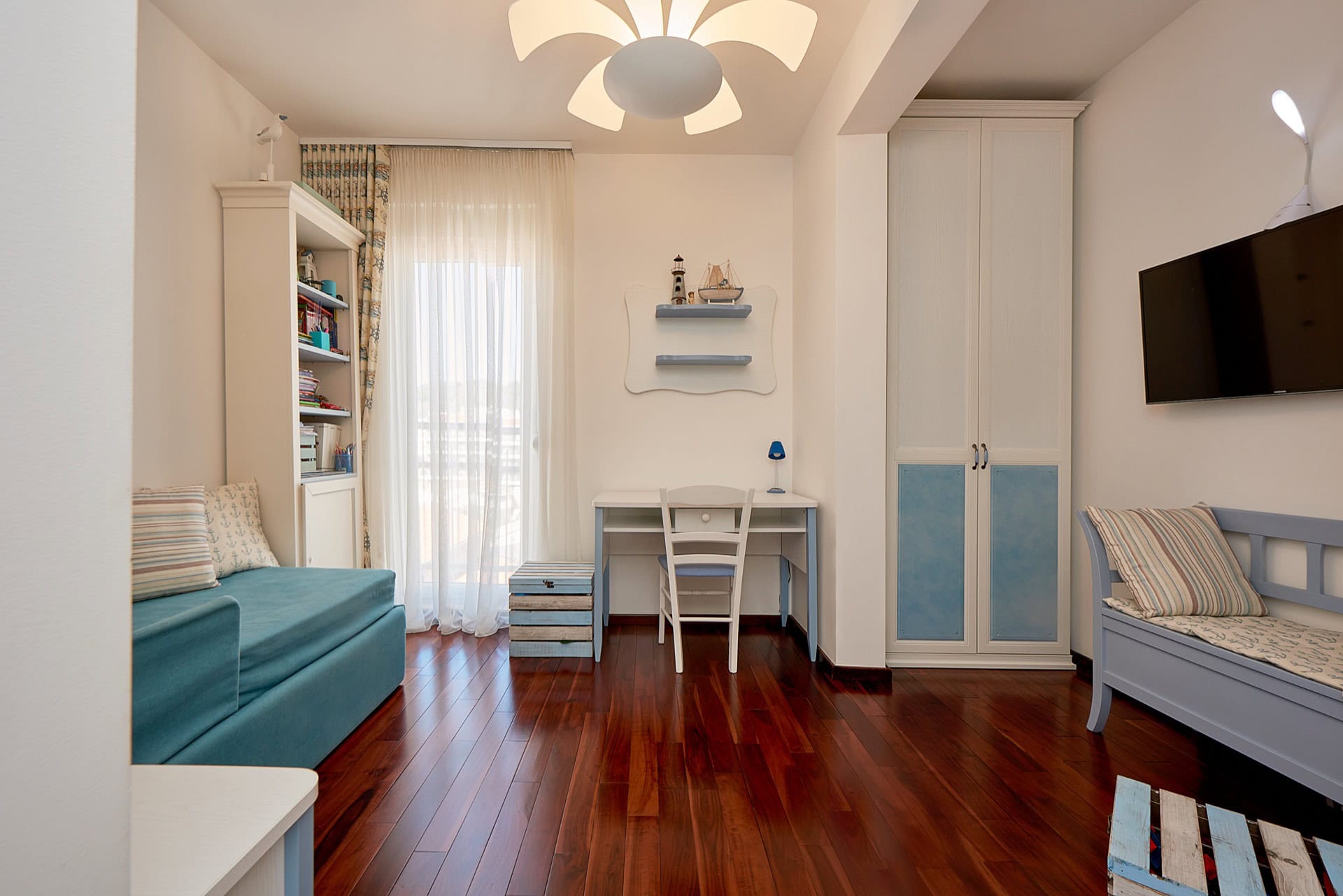 Kinderzimmer im maritimen Stil mit weißen Möbeln, Schreibtisch und Sofa in einer Wohnung in Bečići, Montenegro