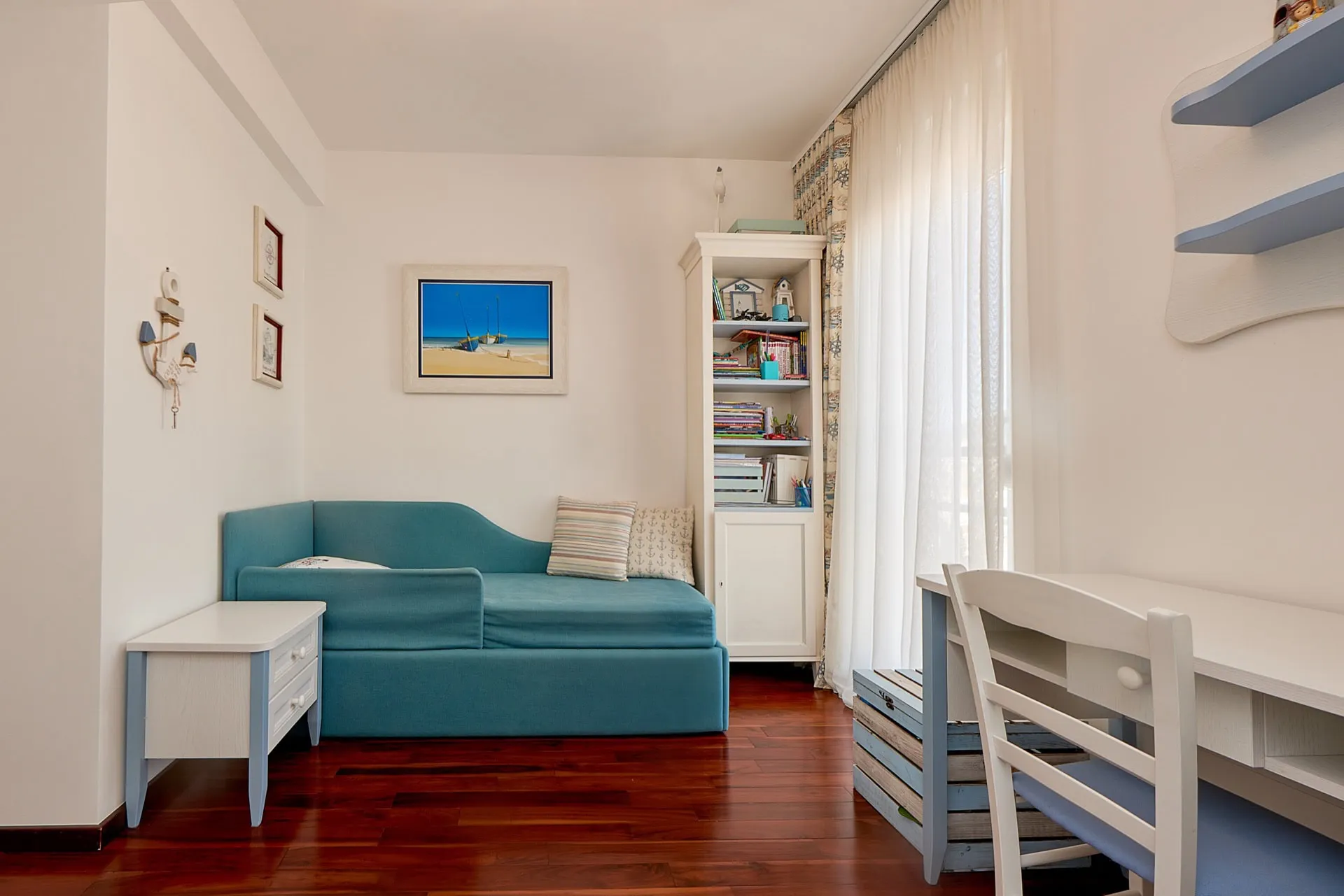 Kinderzimmer im maritimen Stil mit blauem Sofa, Schreibtisch und weißen Möbeln im Penthouse in Bečići, Montenegro