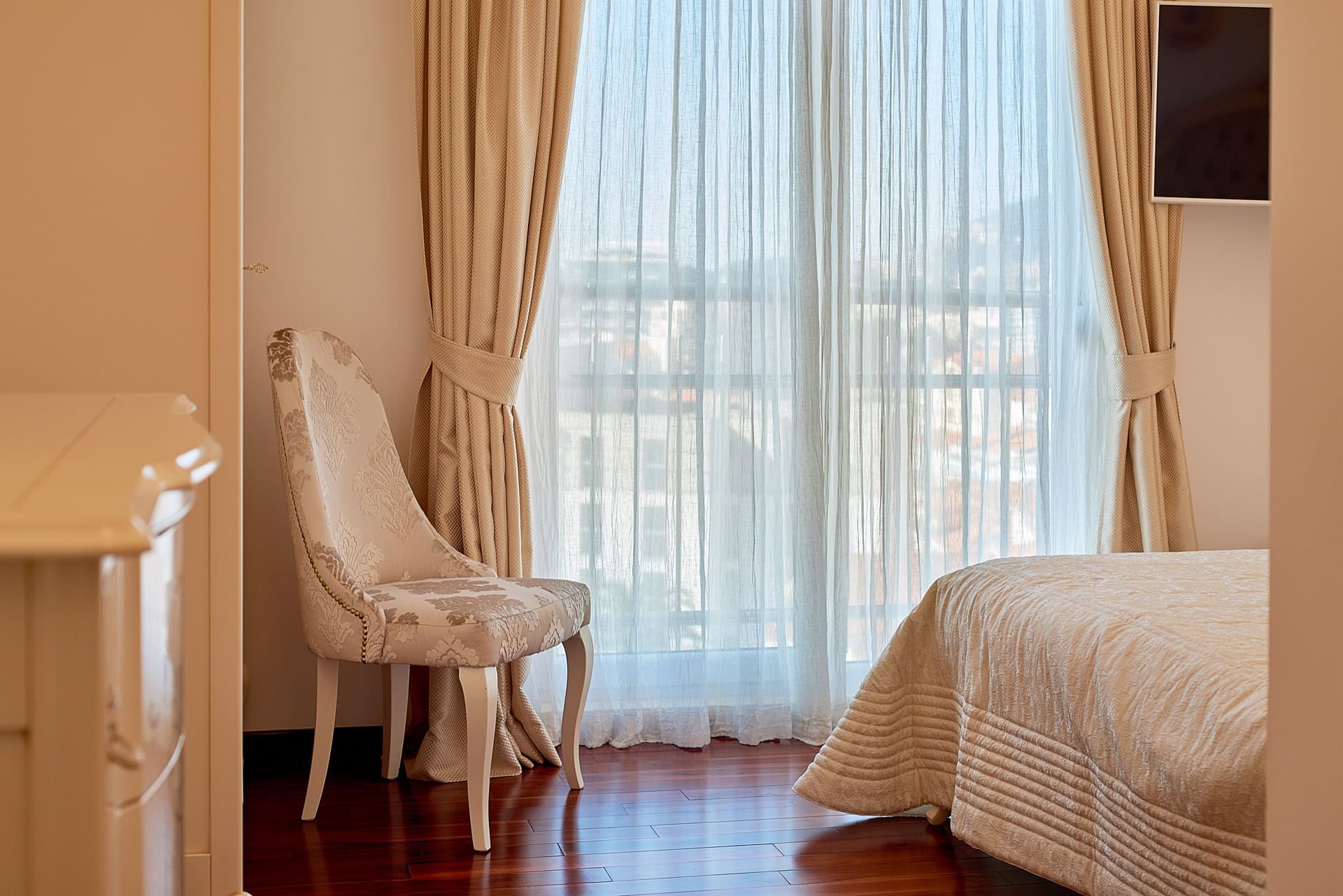 Schlafzimmer mit Sessel im klassischen Stil, Panoramafenster und Parkett im Penthouse, Bečići, Montenegro