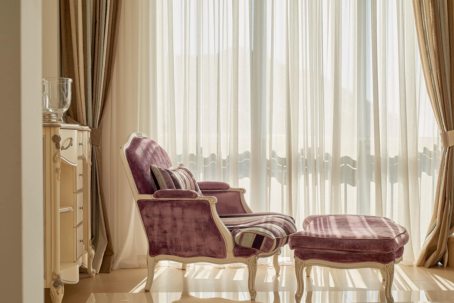 Gemütliches Schlafzimmer mit klassischem lila Sessel und Hocker in einem exklusiven Penthouse in Bečići, Montenegro