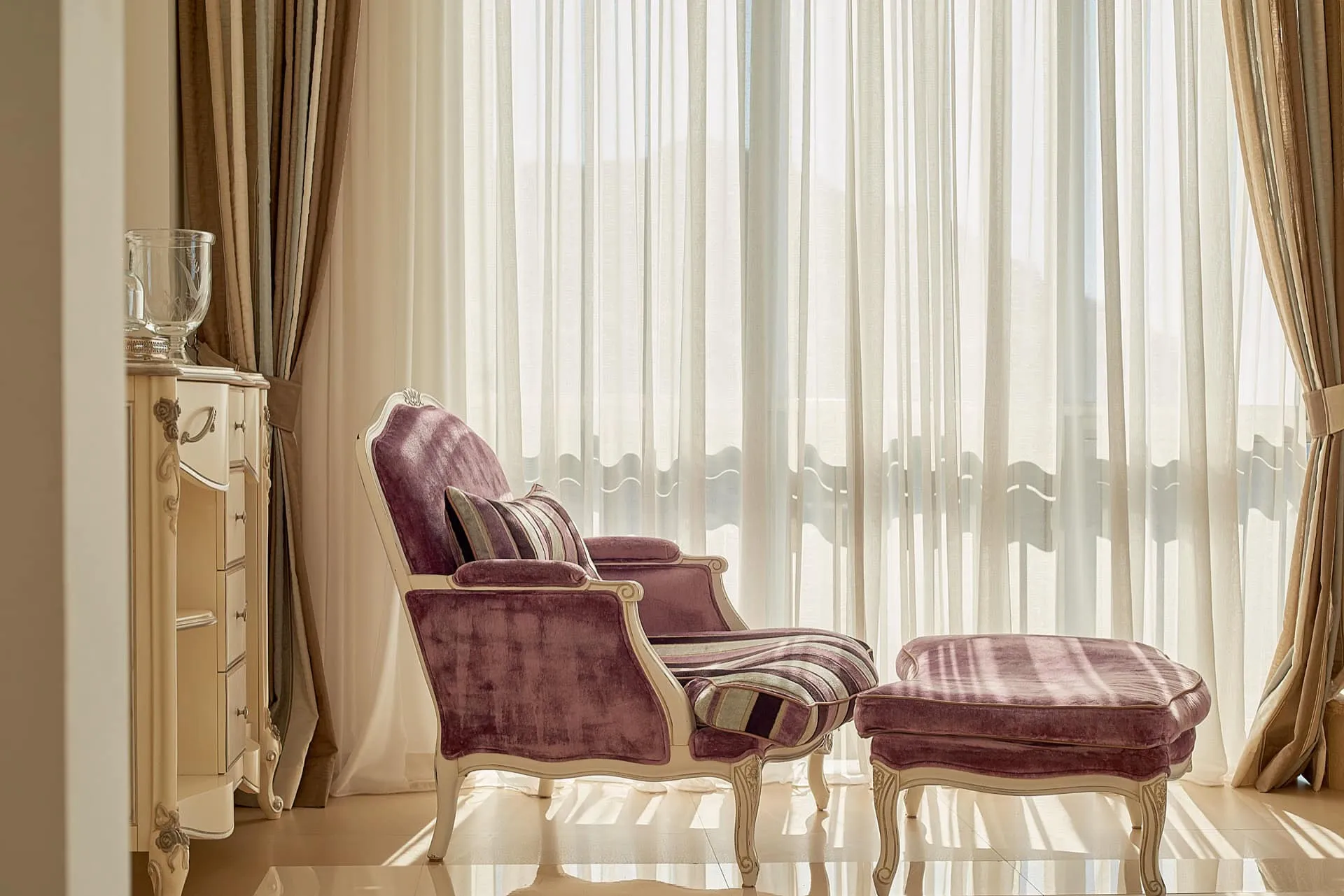 Gemütliches Schlafzimmer mit klassischem lila Sessel und Hocker in einem exklusiven Penthouse in Bečići, Montenegro
