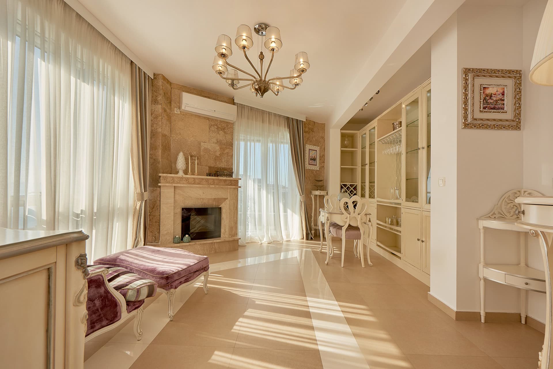 Geräumiges Wohnzimmer mit Kamin, weißen Möbeln und Panoramafenstern im Penthouse in Bečići, Montenegro