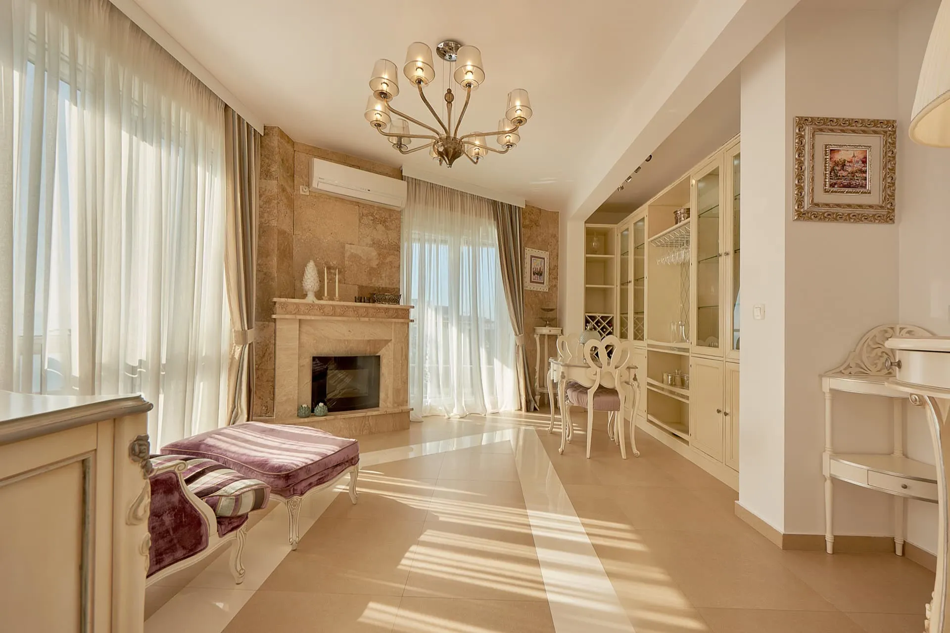 Geräumiges Wohnzimmer mit Kamin, weißen Möbeln und Panoramafenstern im Penthouse in Bečići, Montenegro