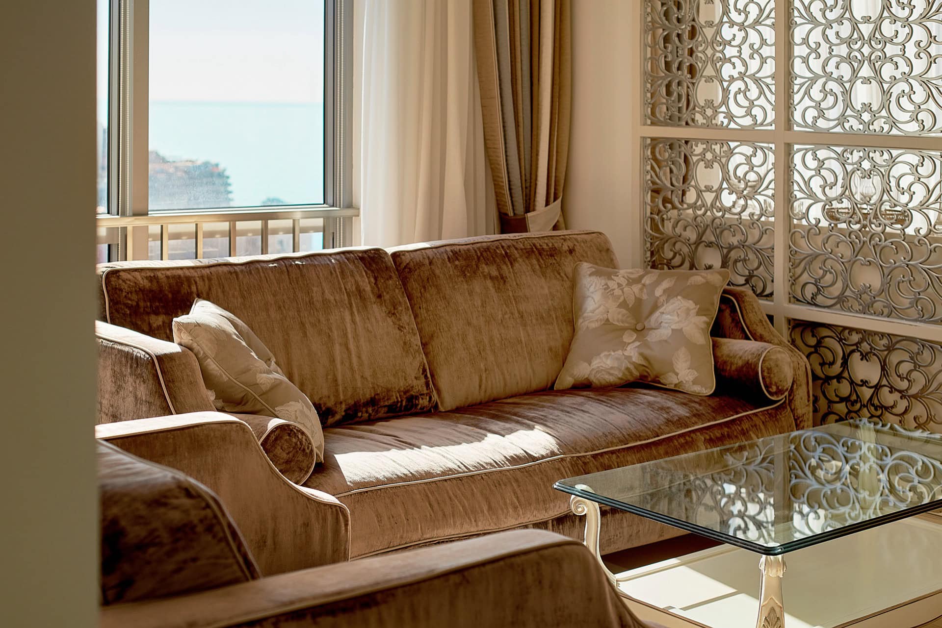 Wohnzimmer mit weichem Velourssofa, Glastisch und Meerblick im Penthouse in Bečići, Montenegro