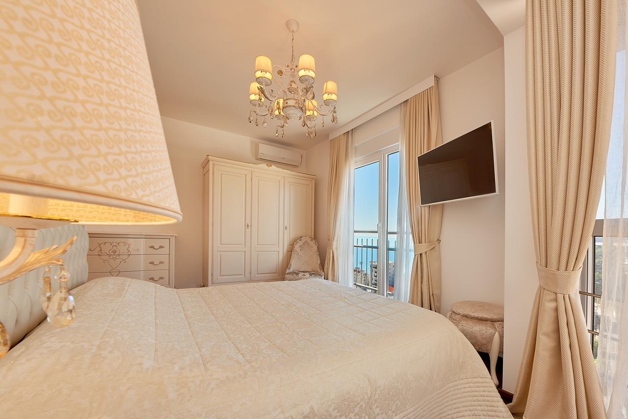 Helle Schlafzimmer mit Doppelbett, Kleiderschrank und Meerblick im Penthouse in Bečići, Montenegro