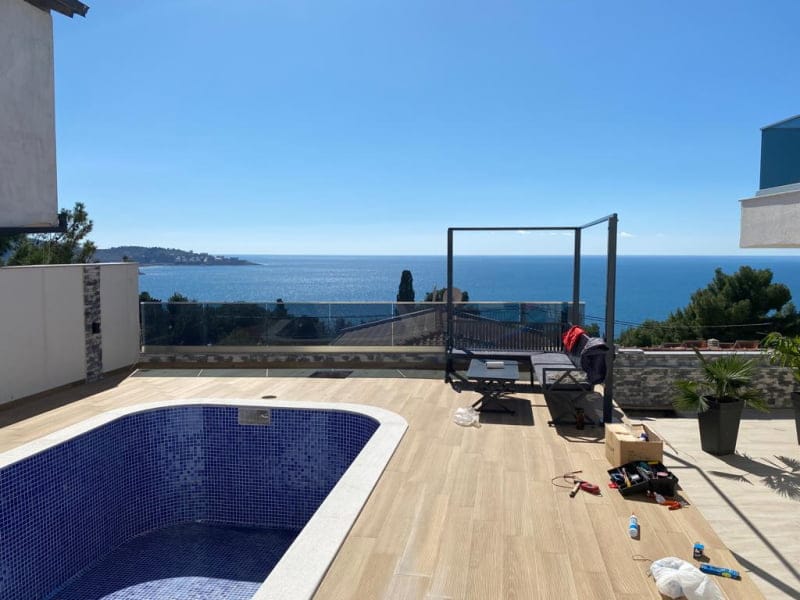 Terrace with a pool and panoramic sea view in a house, Šušanj, Montenegro: modern finishes and a lounge area.