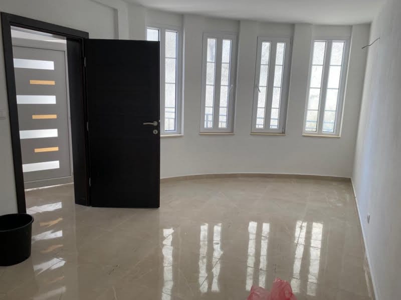 Bright living room with panoramic windows and marble flooring in a new building, Shushan, Montenegro.