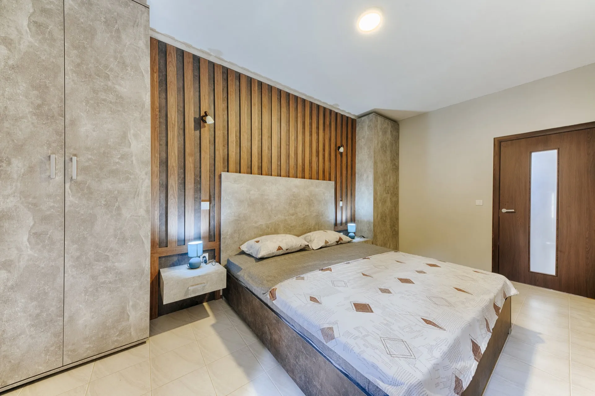 Modern bedroom with a double bed and wooden panels in the interior of a villa in Utjeha, Montenegro.