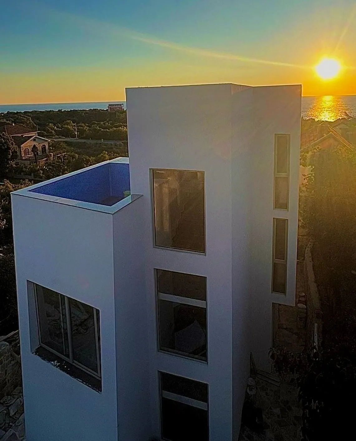 Modern villa with a rooftop pool and sea view in Utjeha, Montenegro, at sunset.