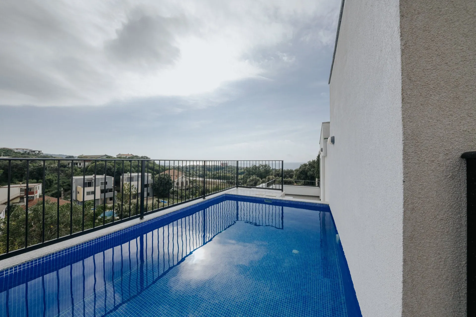 Open-air pool on the villa terrace in Utjeha, Montenegro, with panoramic views of the sea and green surroundings.