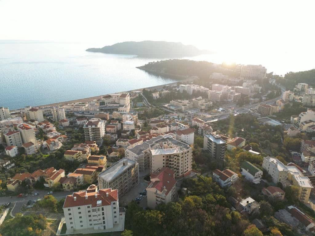 Panoramski pogled iz vazduha na stambeni kompleks i morsku obalu u Bečićima, Crna Gora.