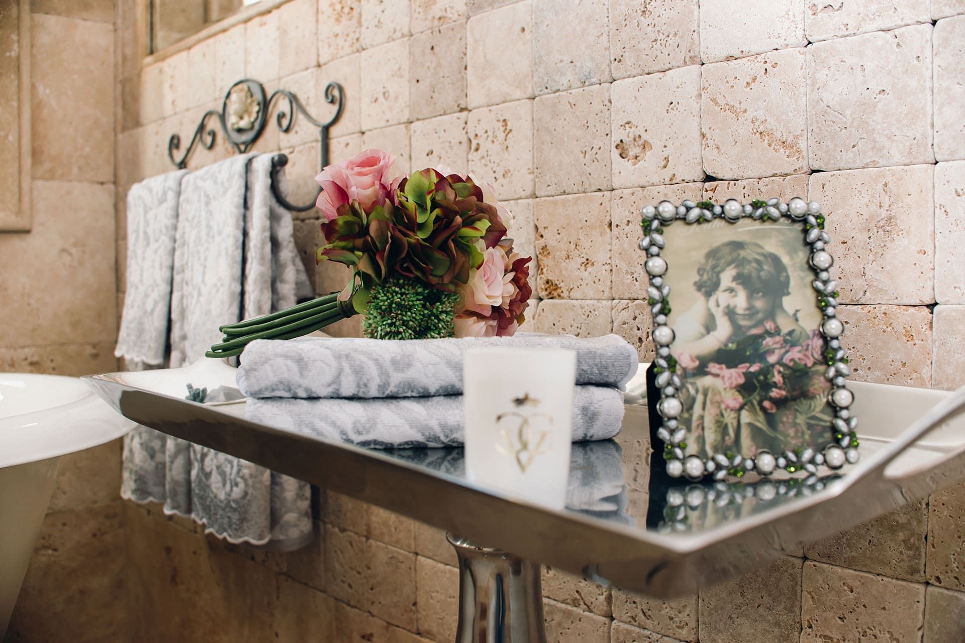 Salle de bains dans une villa à Reževići, Monténégro : finition en pierre naturelle, décoration, serviettes et intérieur élégant.
