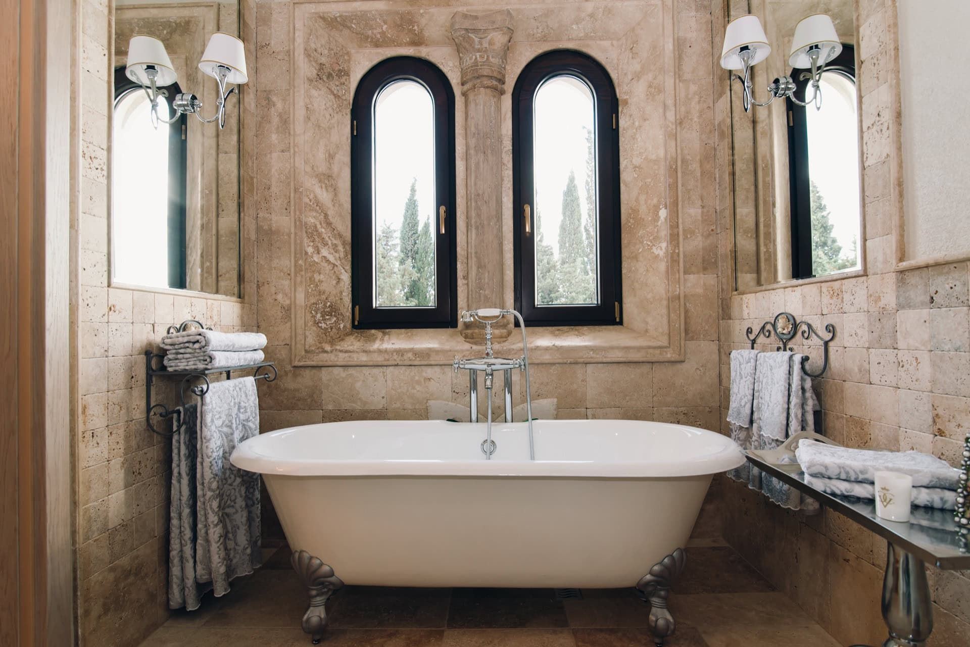 Salle de bains luxueuse avec baignoire îlot et finitions en travertin dans une villa à Reževići, Monténégro.