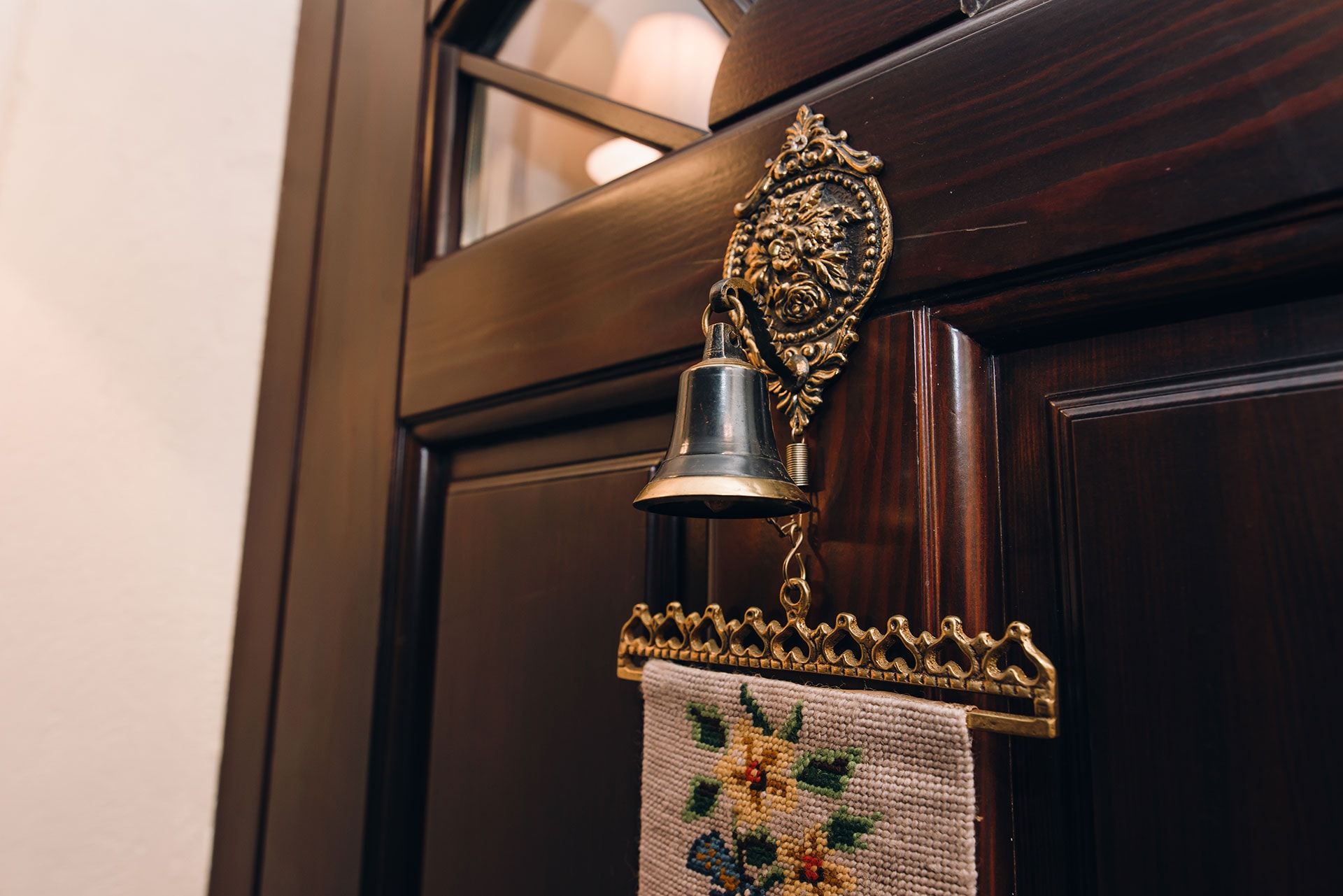 Clochette de porte vintage sur une porte en bois d’une villa à Reževići, Monténégro, décoration intérieure de style classique.