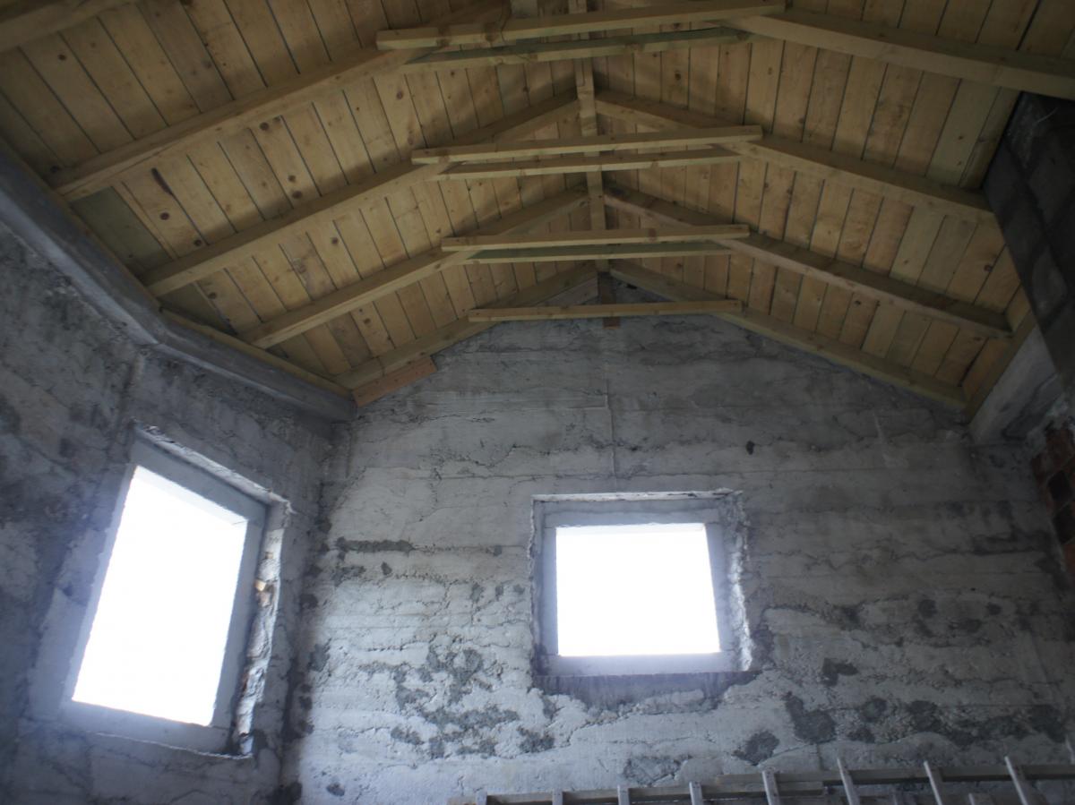 Hausbau in Radovici, Montenegro: Betonwände und hölzerne Dachsparren im Rohbau.