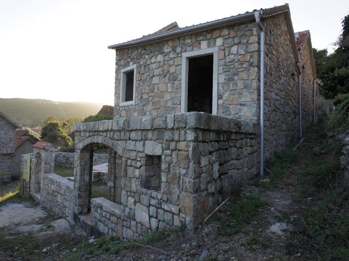 Zweistöckiges Haus aus Naturstein im traditionellen Stil im Dorf Radovići, Montenegro, Außenansicht.