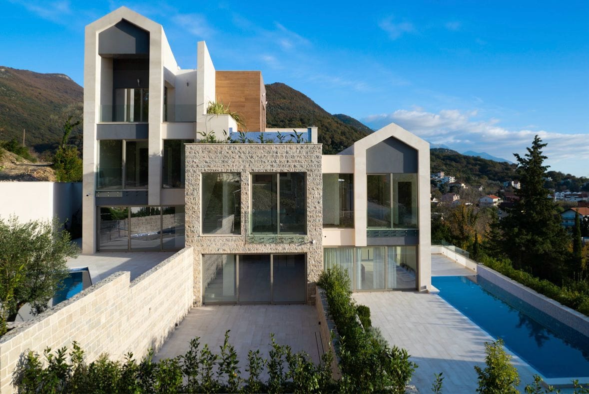 Moderne Villa mit Pool und Panoramaverglasung in Tivat, Montenegro: Blick auf die Fassade und die Terrasse des Objekts.