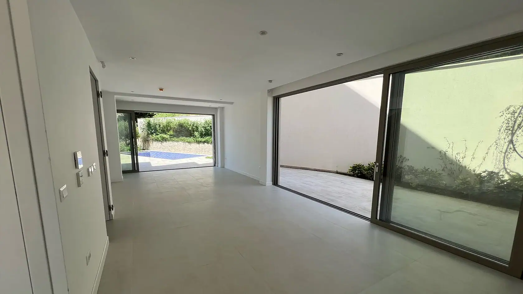 Geräumiges Wohnzimmer mit Panoramafenstern, Zugang zur Terrasse und Pool in der Wohnanlage, Tivat, Montenegro.