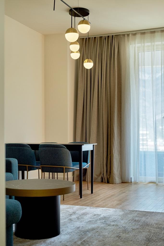 Nowoczesny salon z jadalnią w apartamencie, Bečići, Czarnogóra: stylowe meble, panoramiczne okna i dekoracje.