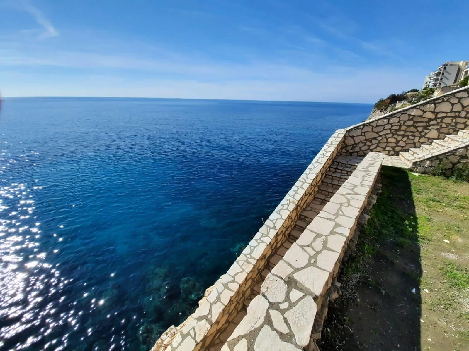 Escalier en pierre menant à la mer dans une villa à Dobra Voda, Kruče, Monténégro, avec vue panoramique sur la côte adriatique.