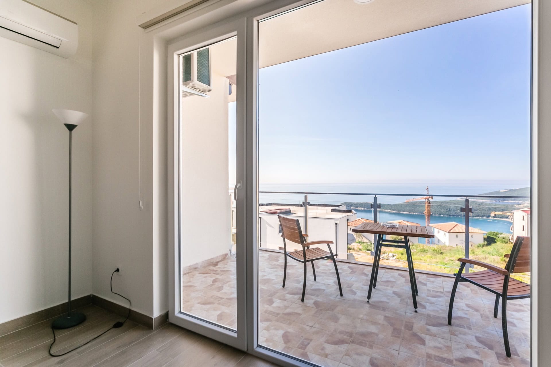 Balcon avec mobilier et vue panoramique sur la mer dans l’appartement, Seoce, Budva, Monténégro. Intérieur moderne avec accès à la terrasse.