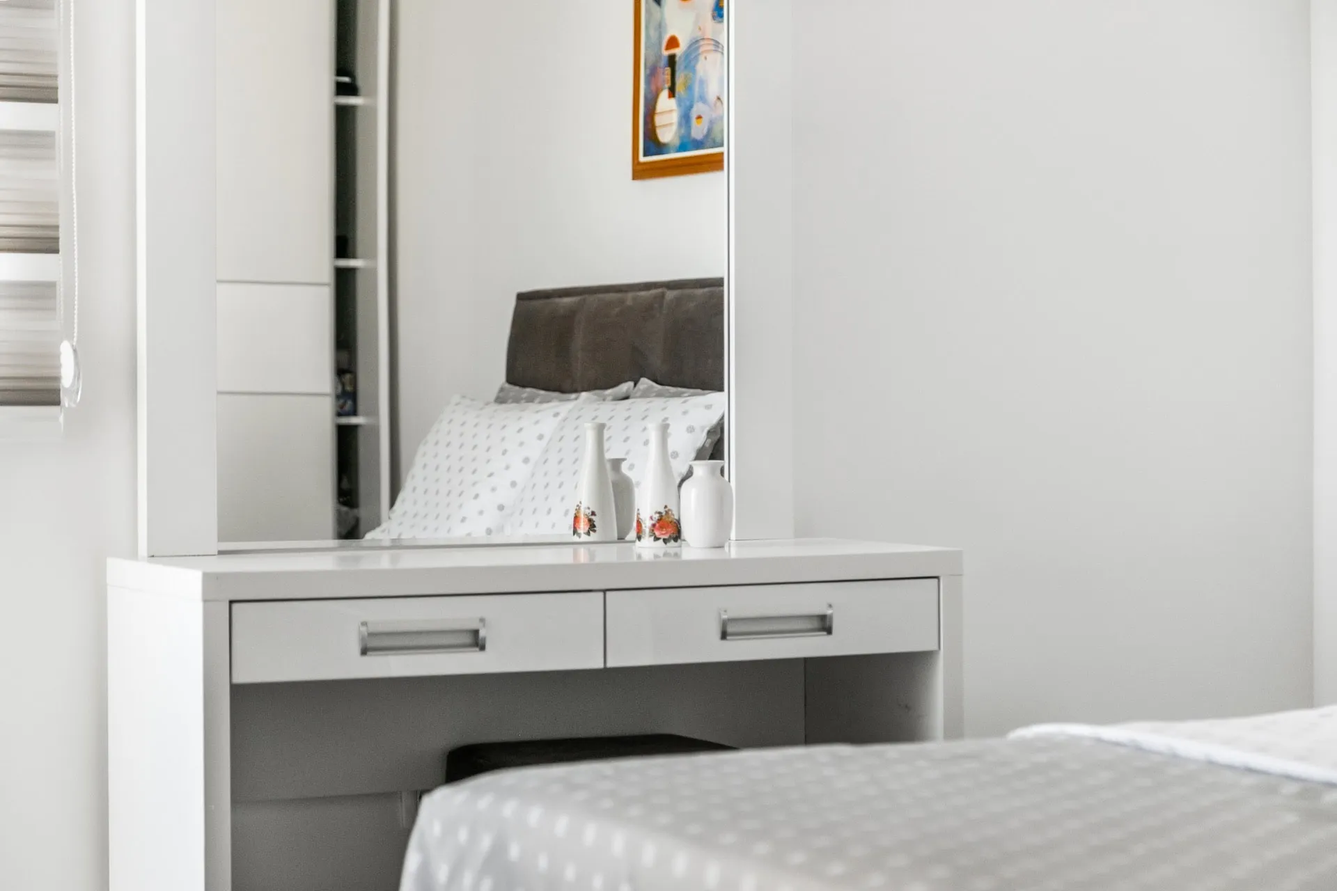 Weißer Schminktisch mit Spiegel im Schlafzimmer einer Wohnung in Budva, Montenegro. Moderne Möbel und Dekor.