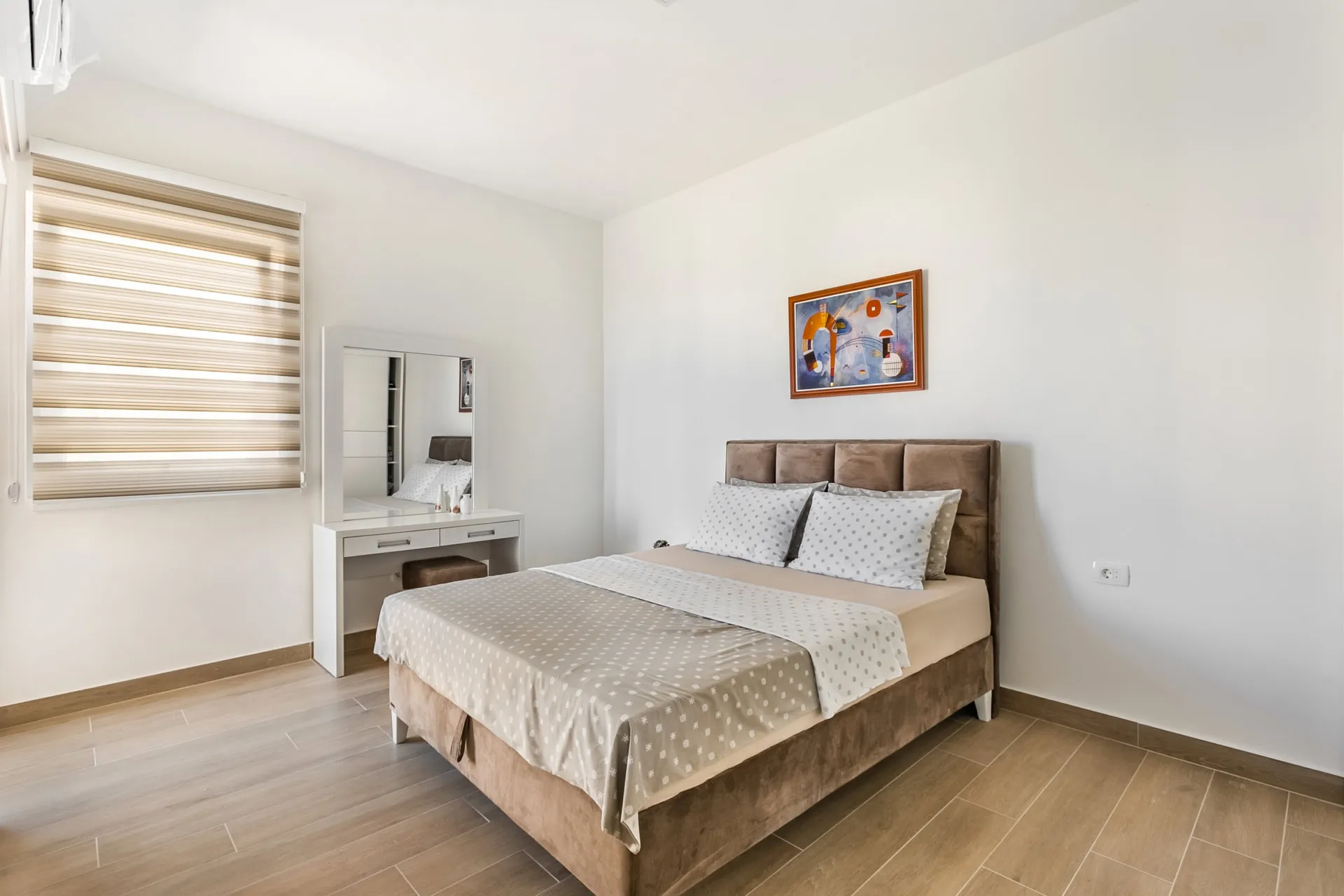 Helles Schlafzimmer mit Doppelbett und Schminktisch in einer Wohnung, Seoce, Budva, Montenegro.
